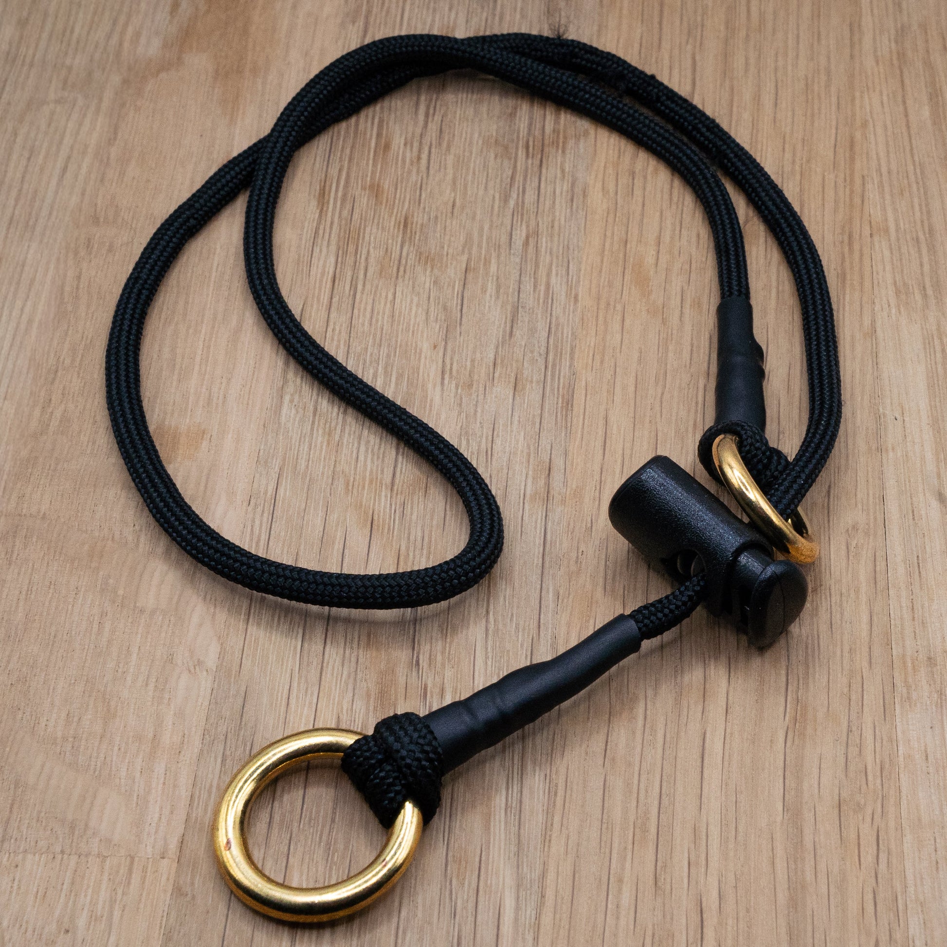 Black paracord Slip Collar with Solid brass 'O' rings and a cord stopper